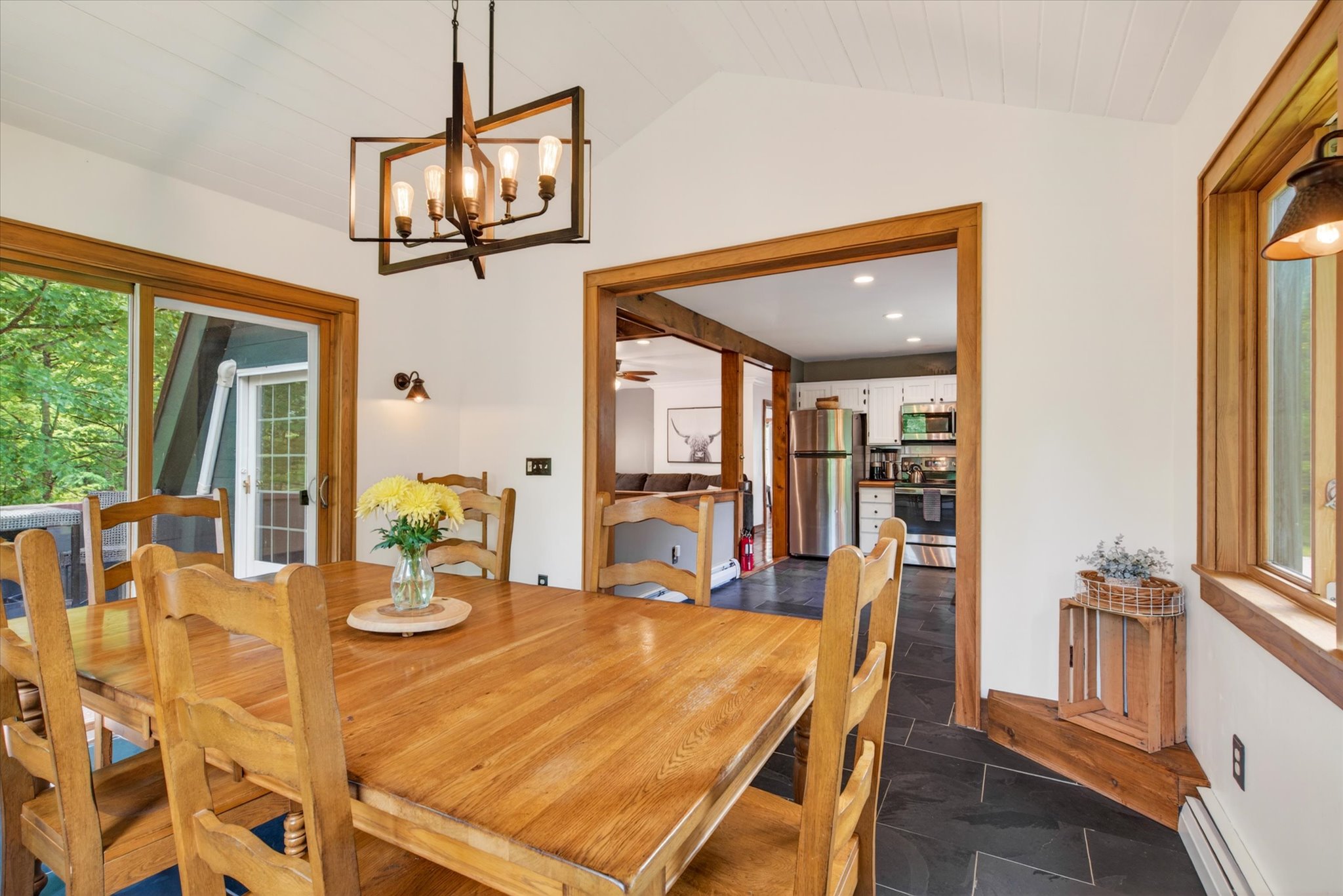 Dining room with kitchen visible in background — Slippery Slope Chalet