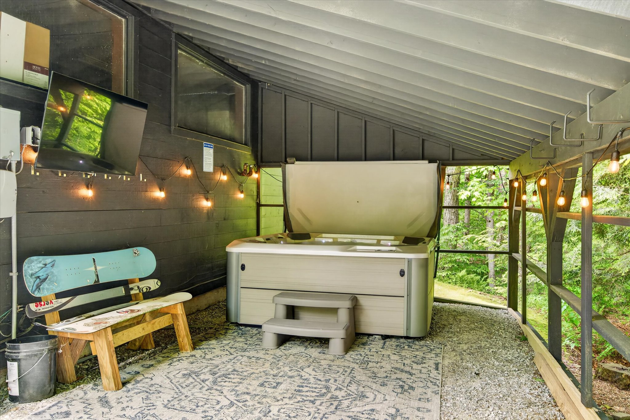 Hot tub shelter interior with TV and Edison lights — Slippery Slope Chalet